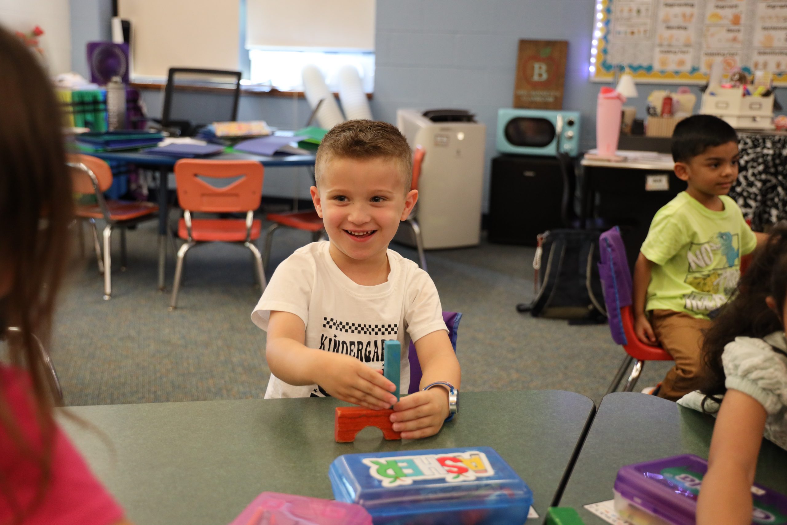 van schaick elementary student works on chromebook in class while writing on paper