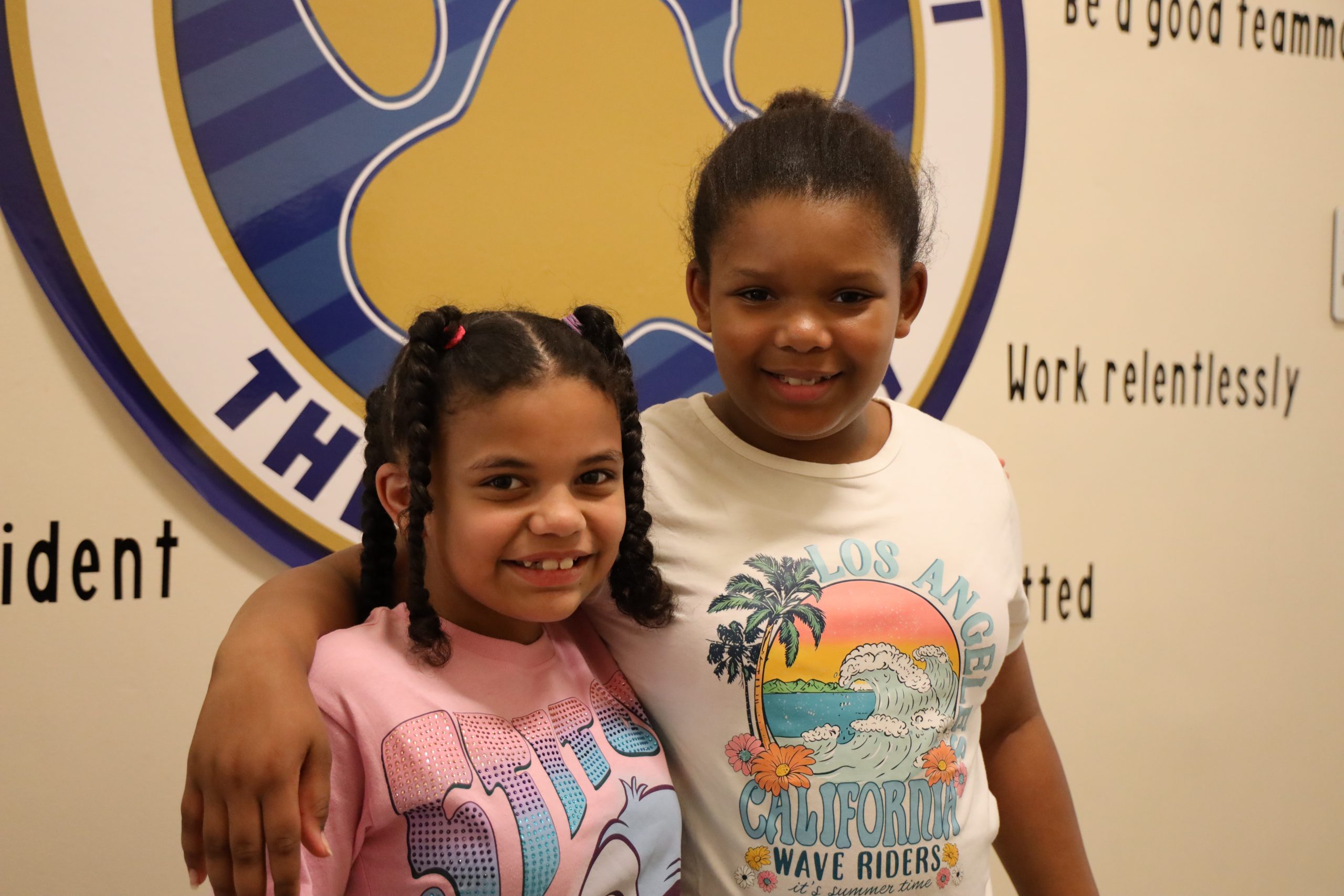 van schaick elementary students stand in front of a winter-themed display with palm trees